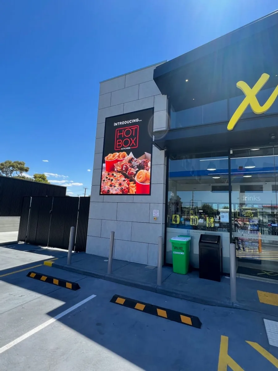 High-brightness LED display mounted on a building at a service station